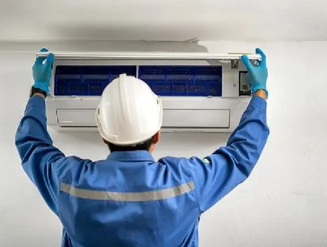 professional AC service technician performing maintenance on air conditioner